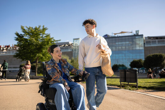 Young adults enjoying outdoor activity with electric wheelchair