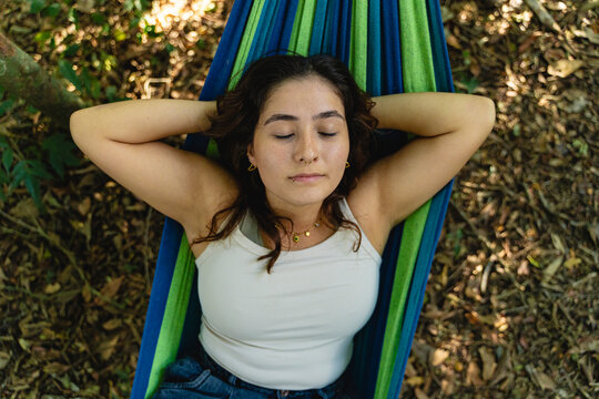 Young woman relaxing in hammock enjoying nature's tranquility