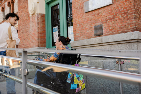 People communicating at bottom of an accessible ramp