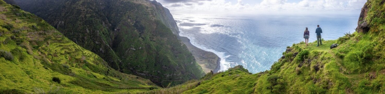 Two adventurers enjoying views of cliffs and sea, coastal landscape, Ponta da Leideira viewpoint, near Calhau das Achadas, Madeira, Portugal