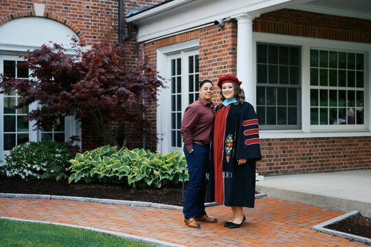 portrait of doctorate graduate with her wife on campus