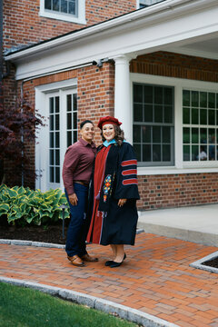portrait of doctorate graduate with her wife on campus
