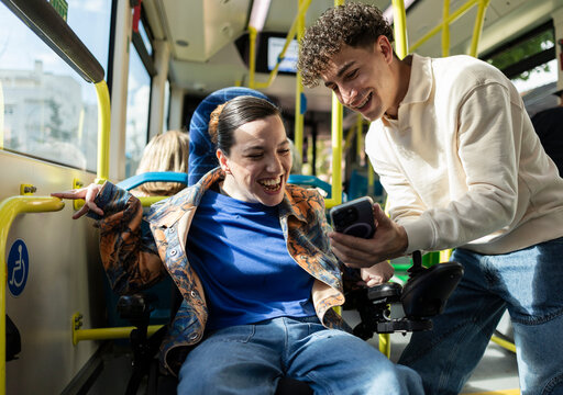 Diverse friends sharing social media content on accessible bus