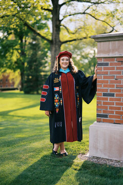 smiling latina doctorate on graduation day in all her regalia