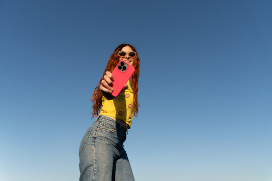 Young Woman Takes Selfie blue sky 