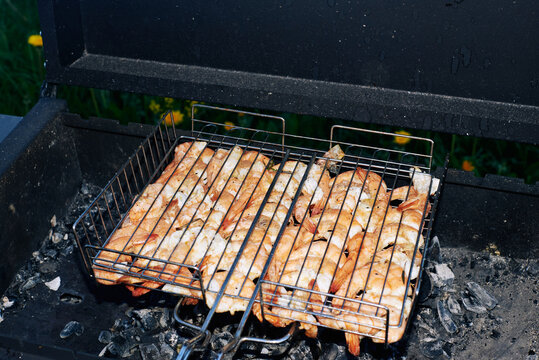 Grilling shrimp outdoors on a sunny day.
