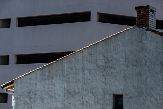 Angular roofline crossing muted facade and parking grid