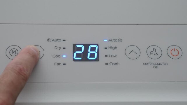 Turning Down Temperature on Thermostat in Summer in Hot Weather. Setting Digital Home Thermostat to Cool and Programming Air Conditioner. Adjusting Room Temperature to Energy Saving in Summer Heat.