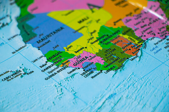 World map closeup with Guinea in sharp focus. Tour or travel concept.