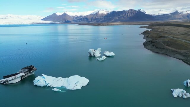 Un lac bleu avec des icebergs et des montagnes en fond