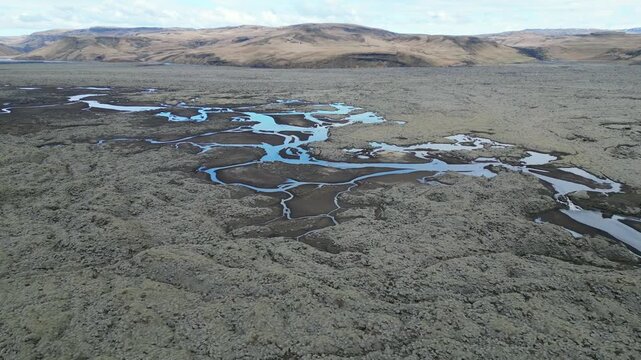 le parcours d'une rivi&egrave;re en vue a&eacute;rienne dans une nature sauvage en Islande avec montagne en fond