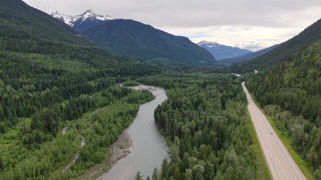 Aerial Drone View of Trans-Canada Highway Curving Through Dense Forest and Mountain Pass, BC Canada