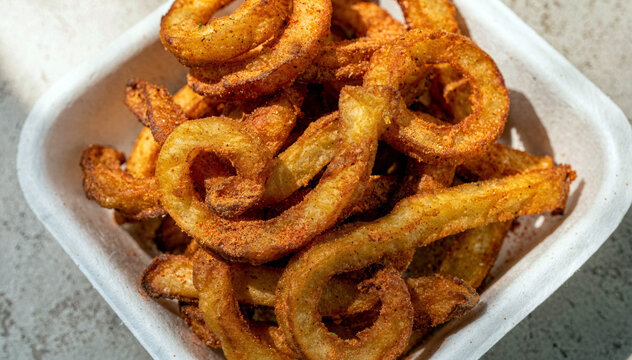 Crispy Seasoned Curly Fries Served in a Takeaway Container with Golden Crunchy Texture