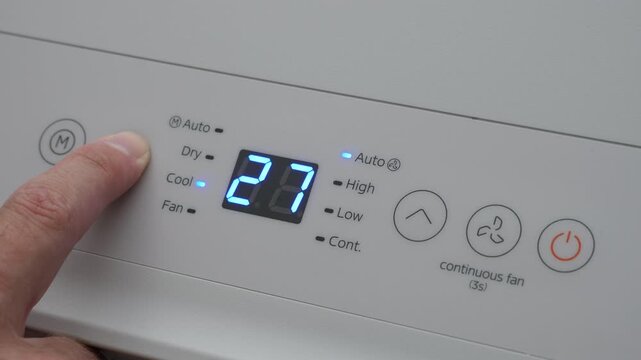 Turning Down Temperature on Thermostat in Summer in Hot Weather. Setting Digital Home Thermostat to Cool and Programming Air Conditioner. Adjusting Room Temperature to Energy Saving in Summer Heat.