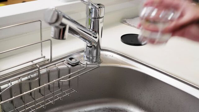 Pouring Fresh Water into Glass and Lifting to Drink