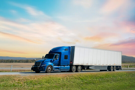 Semi-truck driving on the highway at sunset