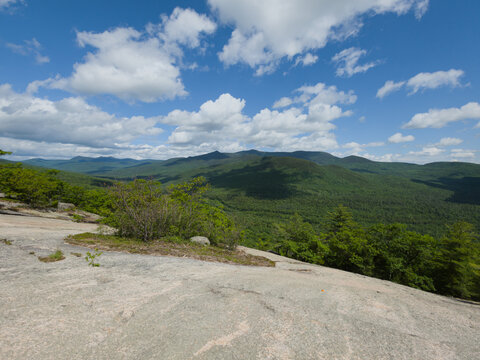 Granite summit ledge overlooking forested mountain ridges, White Mountains New Hampshire