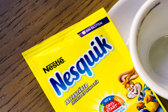 Barcelona, Spain-June 26, 2026. Yellow nesquik drink mix package beside a cup