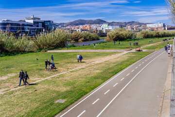 Naklejka premium Barcelona, Spain-June 26, 2026. Barcelona, Spain - March 21, 2021. Promenade and bicycle lane on the banks of the Besos river, Sant Adriá in Barcelona