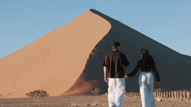 Romantic couple holding hands and hugging in Sossusvlei Namibia desert