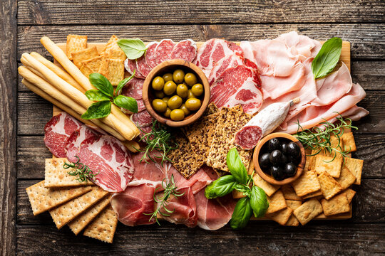 Appetizers with differents antipasti, charcuterie, snacks and red wine. Sausage, ham, tapas, olives and crackers for buffet party. Top view, flat lay