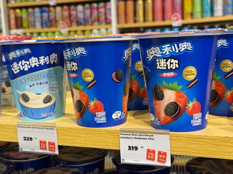 Khimki, Russia - June 25, 2026: Ice cream cups featuring Oreo cookies and strawberry flavor are arranged on a wooden shelf in a grocery store