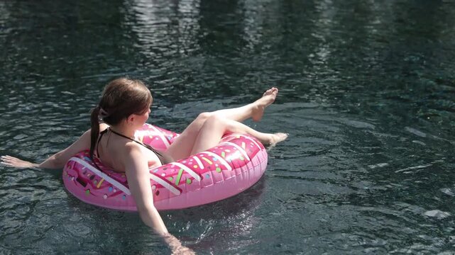 Young woman relaxing on inflatable donut float