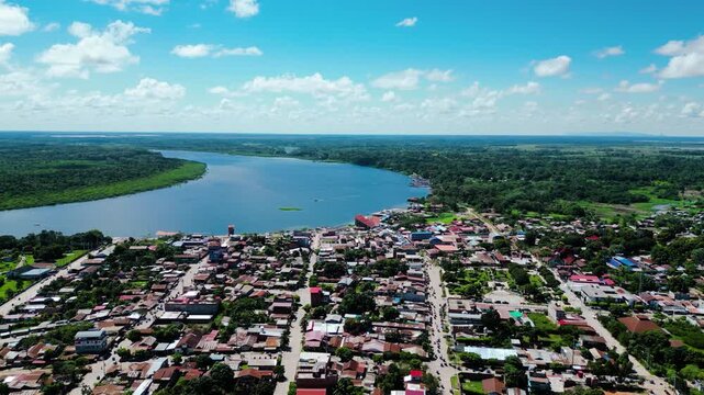 High altitude establishing drone shot over Yarinacocha, revealing the massive Ucayali River on the vast tropical landscape horizon.