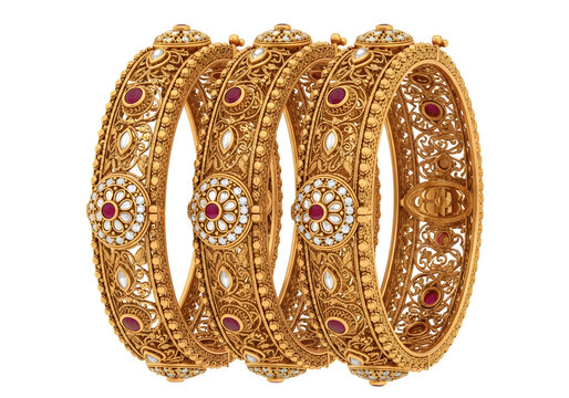 Intricately designed gold bangles with red and white gemstones isolated on transparent background