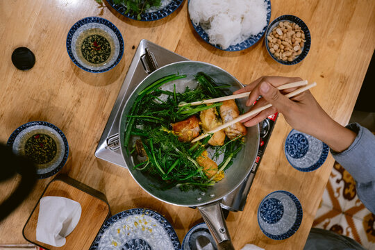 Traditional Hanoi catfish with turmeric and fresh greens, prepared on the table with noodles, peanuts, fish sauce and lime