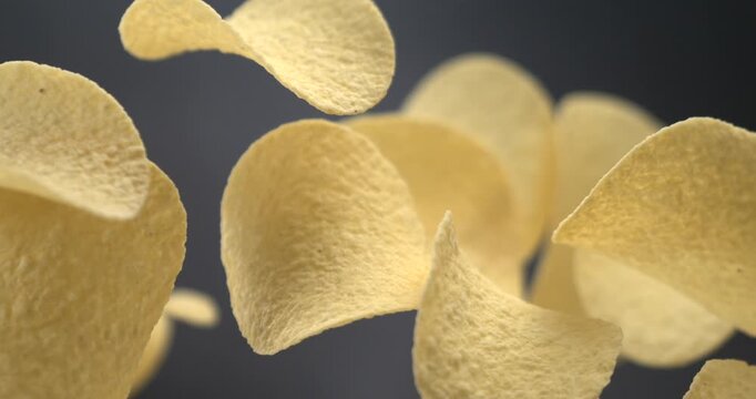 Potato chips flying in slow motion 1000 fps against blue background