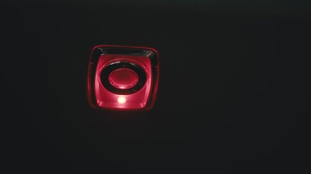 Flashing red power button on black background