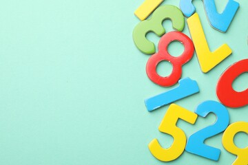 Fototapeta premium Many colorful numbers on turquoise background, flat lay. Space for text