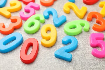 Fototapeta premium Many colorful numbers on grey textured table, closeup