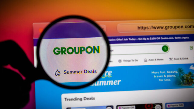 Magnifying glass over the groupon website logo on a computer screen