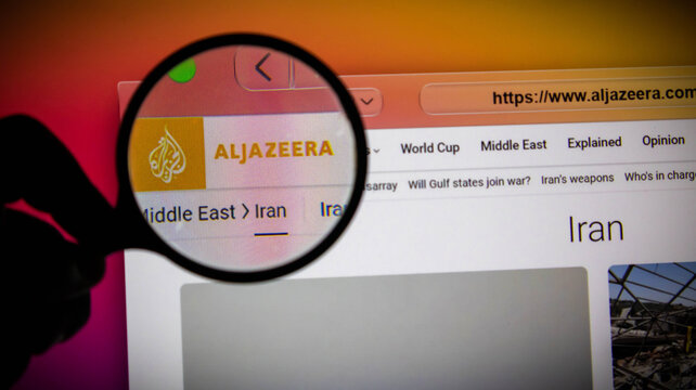 Closeup of a magnifying glass over the al jazeera website on a computer screen