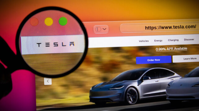 Closeup of a magnifying glass over the tesla website on a computer screen