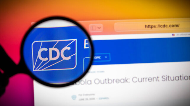 Magnifying glass over a computer screen showing a fake cdc website