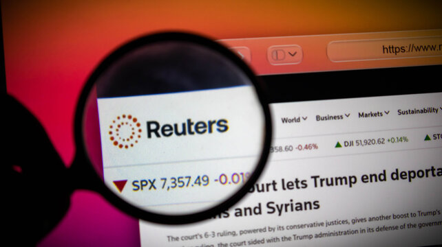 Magnifying glass focused on the reuters news website on a computer screen