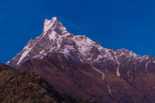 Iconic view of Machapuchare, also known as Fishtail Mountain, rising dramatically in the Annapurna region of the Himalayas in Nepal. The sacred peak is easily recognized by its distinctive twin-summit
