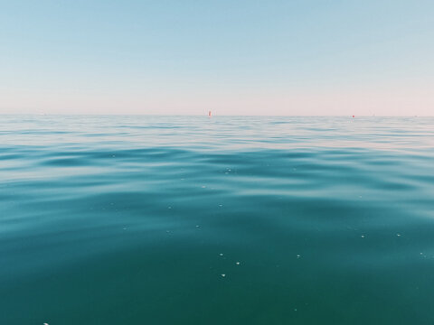 V&iacute;deo 4K de mar abierto en calma, con la superficie del agua en primer plano, horizonte limpio y cielo despejado. La imagen transmite una sensaci&oacute;n minimalista, serena y mediterr&aacute;nea, con movimiento s