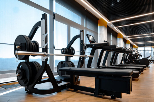 Gimnasio bien iluminado con una gran variedad de equipos para hacer ejercicio
