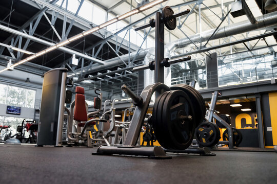 Gimnasio bien iluminado con una gran variedad de equipos para hacer ejercicio