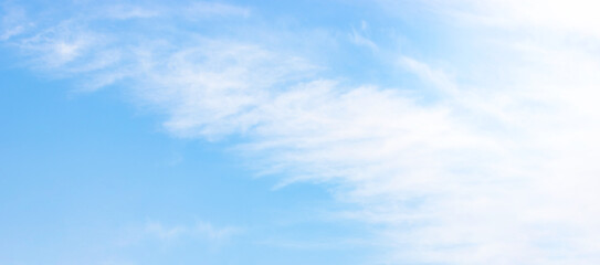Obraz premium Beautiful bright blue sky background texture with soft light white cirrus clouds on a clear sunny day full frame panoramic abstract backdrop template with copy space for graphic design.