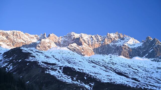 Aerial Drone View of Swiss Alps at Sunrise with Golden Alpenglow Over Snow-Covered Peaks, Uri Alps
