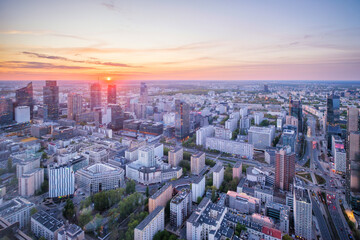 Fototapeta premium High viewpoint over the Warsaw skyline in Poland with skyscrapers, cityscape layers, city depth, sunset color and dramatic sky