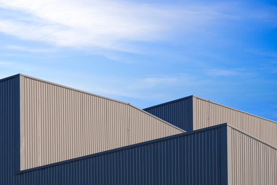 Warehouse Factory Industry Building Background, Architecture Exterior Geometric Metal Wall of Modern Gray Aluminum Rooftop with Blue Sky in Minimal Design, Low angle view