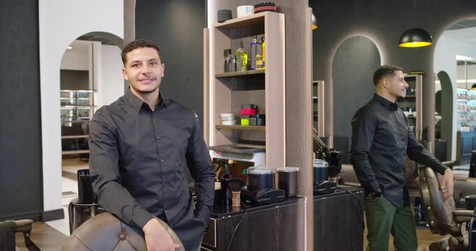 African American men at salon, man acknowledging peer in mirror, shifting and resting hand on chair