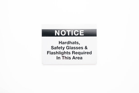 Notice:  Hardhats, Safety Glasses, and Flashlights Required in this Area sign on a white background.