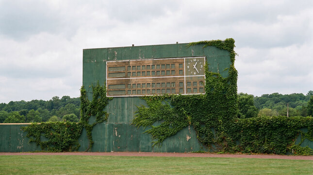 Vibrant green stadium outfield wall featuring traditional empty analog scoreboards ready for creative sports marketing